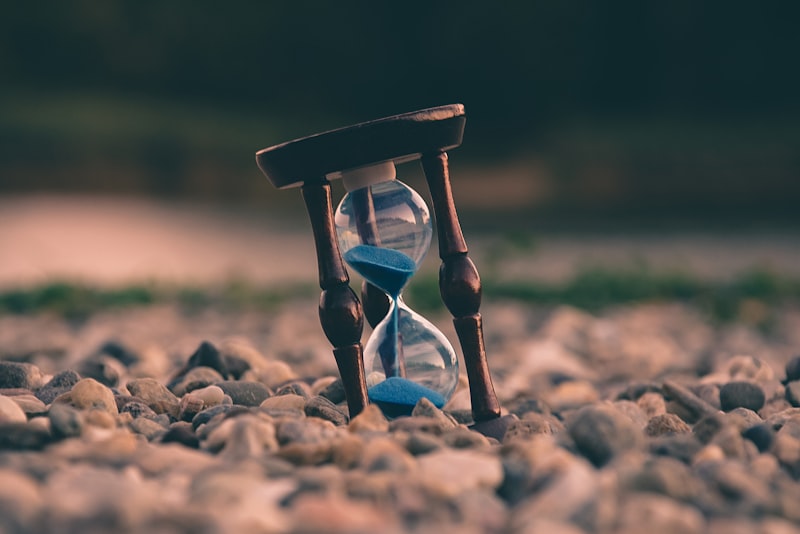 A simple wall clock showing the passage of time against a plain background.