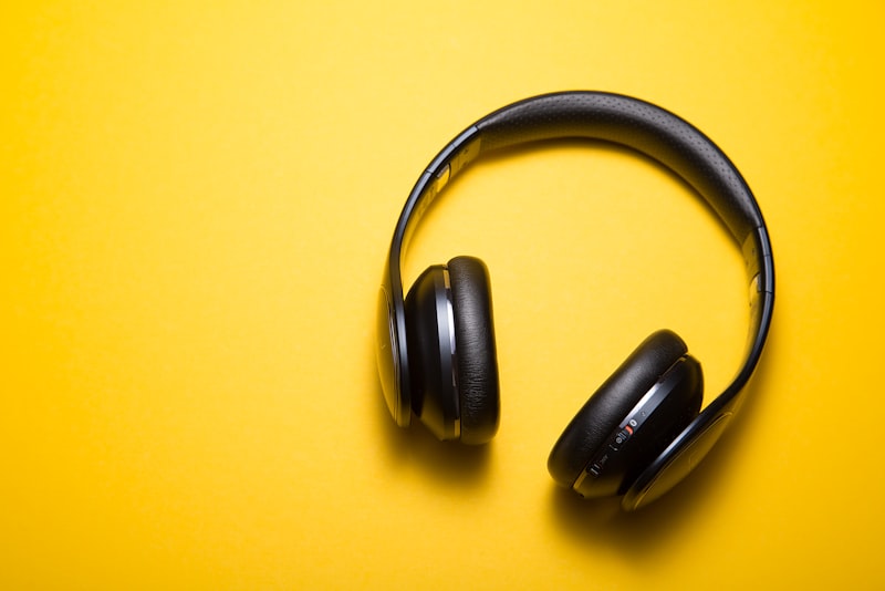 Someone wearing headphones while walking outdoors on a bright day.