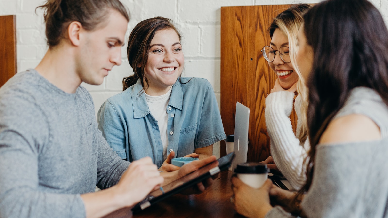 A group of friends talking together around a table outdoors.